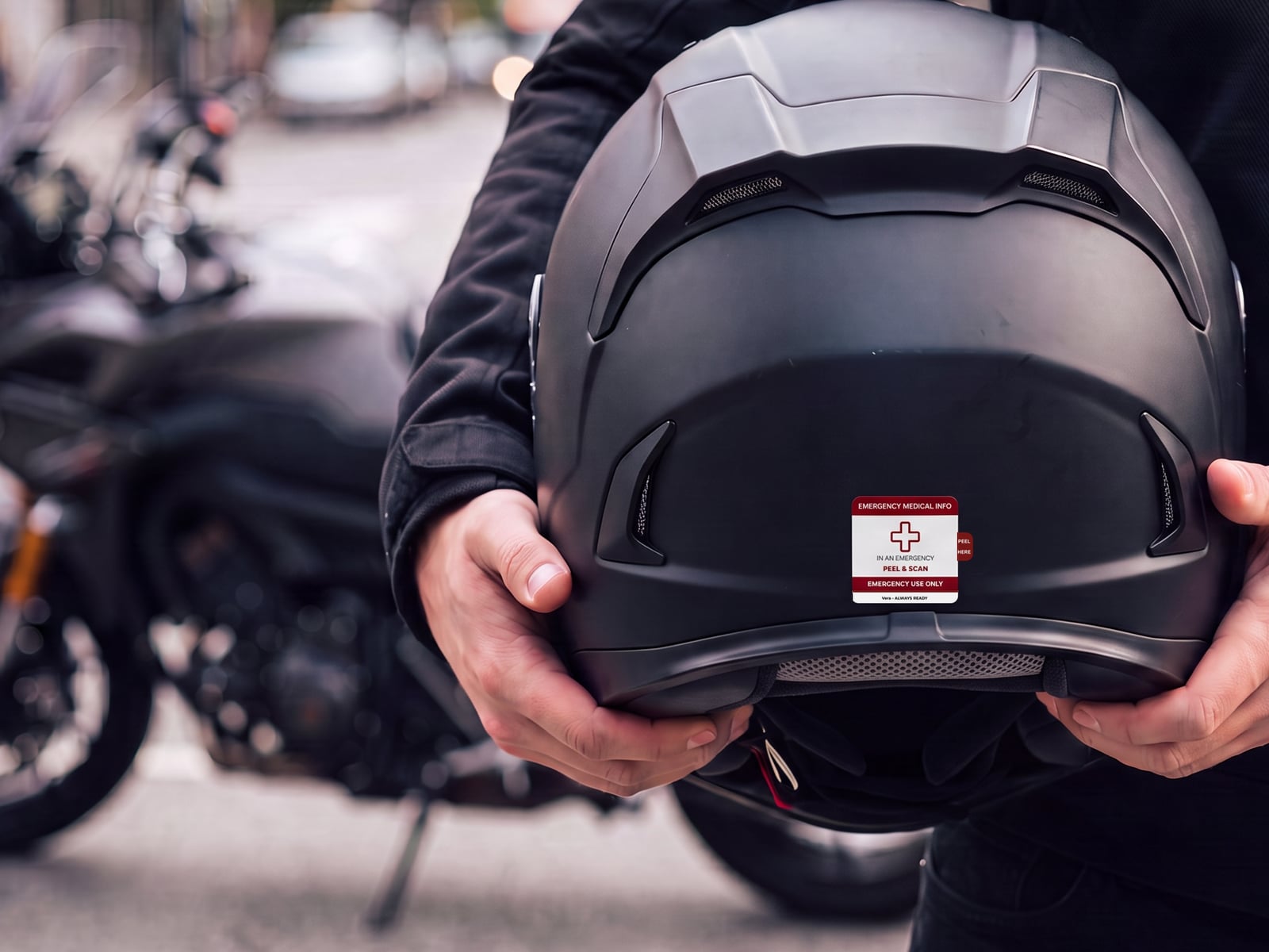 Rider holding a helmet with a Vera emergency medical sticker